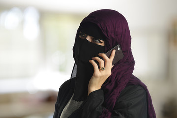 Islamic woman wearing a burqa on the cell phone