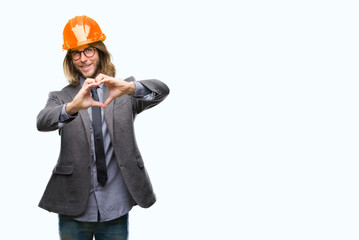 Young handsome architec man with long hair wearing safety helmet over isolated background smiling in love showing heart symbol and shape with hands. Romantic concept.