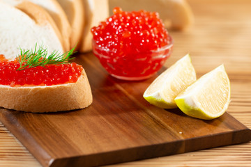 red caviar in glassware on a wooden background in a rustic style with space for text