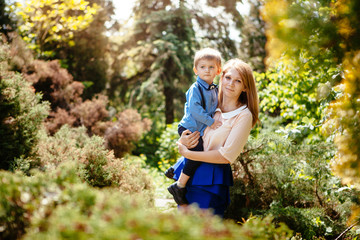 Fototapeta premium Beautiful young mother with child in park with sunshine, happy mothers day