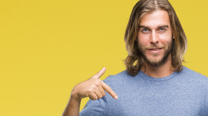 Young handsome man with long hair over isolated background looking confident with smile on face,...