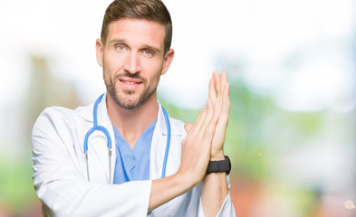 Handsome doctor man wearing medical uniform over isolated background Clapping and applauding happy and joyful, smiling proud hands together