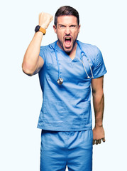 Handsome doctor man wearing medical uniform over isolated background angry and mad raising fist frustrated and furious while shouting with anger. Rage and aggressive concept.