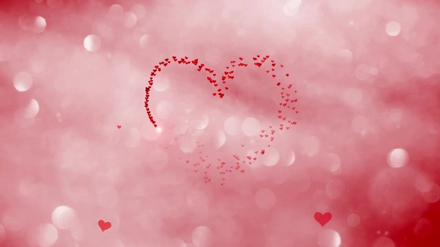 Large group of small red heart shapes in the shape of a big Valenitines day heart on red colored bokeh motion background. 