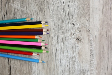 Color pencils with sharpener lying on wooden natural background. Back to school concept. Colorful art studying and painting process. Drawing with pencils. Copy space place for postcard wish.