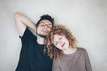 Portrait of a natural caucasian couple of young woman with curly blonde hair and man that share time together, ease and relax enjoying each other