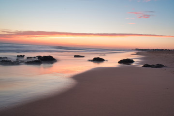 Fototapeta na wymiar Beautiful Calming Sunrise Vacation Landscape Warm Colors Rocks on Shore Coast