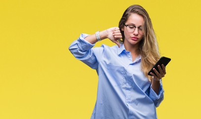 Young beautiful blonde business woman using smartphone over isolated background with angry face, negative sign showing dislike with thumbs down, rejection concept
