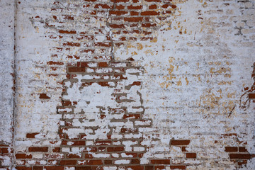 Texture of red brickwork with peeled white paint