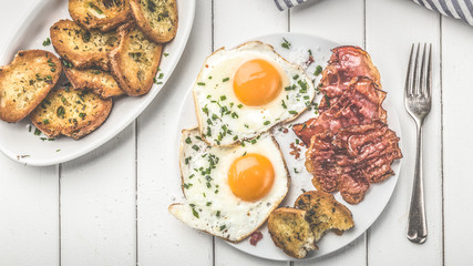 bacon and eggs for breakfast with chives and bread