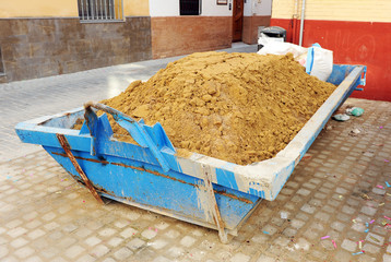 construction container full of sand for the renovation of a residential building in the city