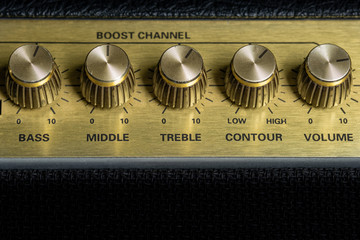 vintage amplifier five knobs horizontal closeup, music recording studio equipment, bottom copy space