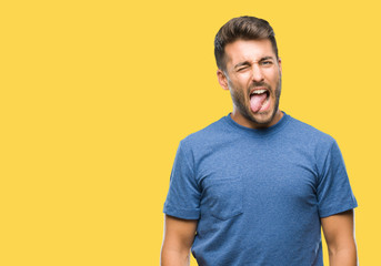 Obraz premium Young handsome man over isolated background sticking tongue out happy with funny expression. Emotion concept.