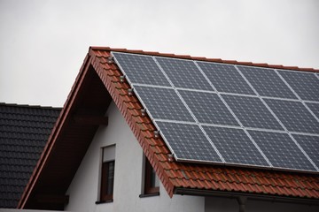 Naklejka premium solar panels on the tiled roof of a residential building