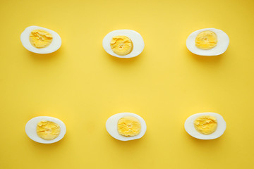 Pattern of boiled eggs on a yellow background. Easter template, top view