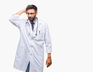 Adult hispanic doctor man over isolated background confuse and wonder about question. Uncertain with doubt, thinking with hand on head. Pensive concept.