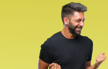 Fototapeta premium Adult hispanic man over isolated background very happy and excited doing winner gesture with arms raised, smiling and screaming for success. Celebration concept.