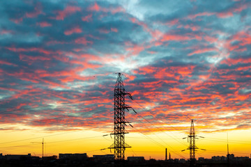 High-voltage electricity pylon and power line against the sunset sky