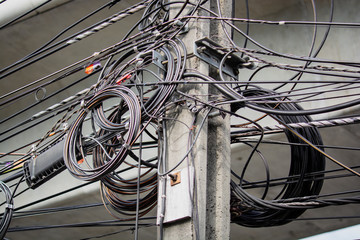 A bunch of tangled power lines or wire cable around the power poles in Thai capital Bangkok.