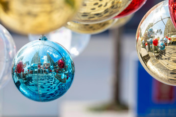 Close up Shiny Xmas balls of assorted kinds on fir colorful bokeh with festive decoration against. Christmas glass baubles ball of Merry Christmas and Happy New Year on abstract background.