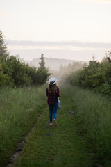 Fototapeta na wymiar single girl meets sunrise in a misty morning in a field in summer