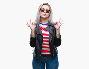 Obraz na płótnie Canvas Young blonde woman wearing fashion jacket and sunglasses over isolated background relax and smiling with eyes closed doing meditation gesture with fingers. Yoga concept.