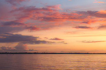 Colourful orange and pink sunset with bright sky and beautiful clouds over Baltic sea.