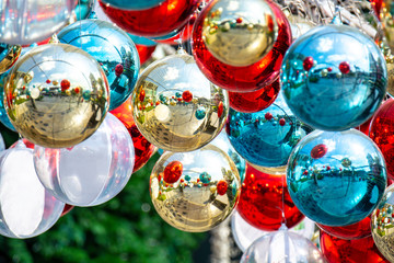 Shiny xmas glass baubles ball hanging on fir over colorful bokeh with festive. Christmas bauble twinkling light and ornament on colurful glitter.Merry Christmas and Happy New Year background.