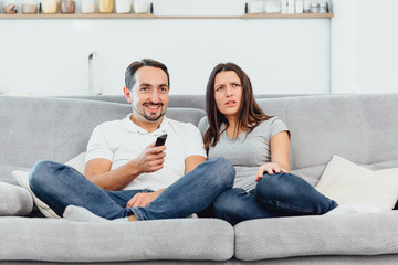 A woman and a man watch TV