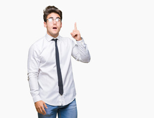 Young business man wearing glasses over isolated background pointing finger up with successful idea. Exited and happy. Number one.
