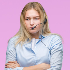 Young caucasian business woman wearing call center headset over isolated background skeptic and nervous, disapproving expression on face with crossed arms. Negative person.