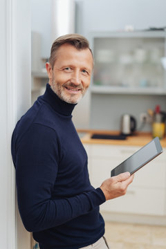 Smiling man with tablet pc, looking at camera