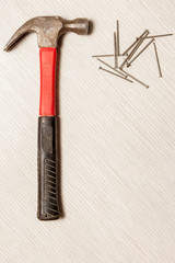 An image of hammer and nails on wooden table