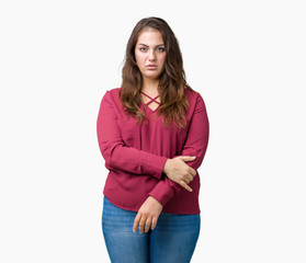 Beautiful plus size young woman over isolated background skeptic and nervous, disapproving expression on face with crossed arms. Negative person.
