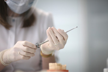 Doctor's hands with the instrument in the operating room of the dental clinic