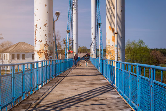 Bridge and wooden walkway across the river. Metal bridge with a wooden road.