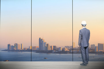 businessman is working  in the office room. Beautiful view on the skyscrapers outside the window.