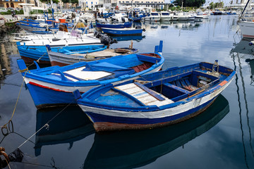 Fototapeta na wymiar Small old fishing boats at sea port in Italy