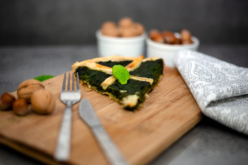 Slice of homemade puff pastry with spinach filling with nuts
