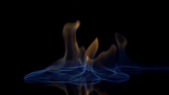 Flames burn on the mirror surface on a black background