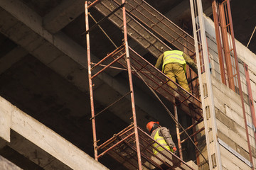 Naklejka premium Welder work at a height in the building under construction.