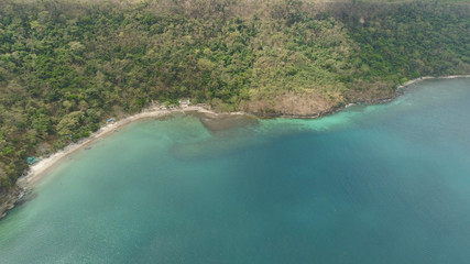 Aerial view of coast with beach in blue lagoon. Philippines, Luzon. Coast ocean with tropical beach, turquoise water. Tropical landscape in Asia.