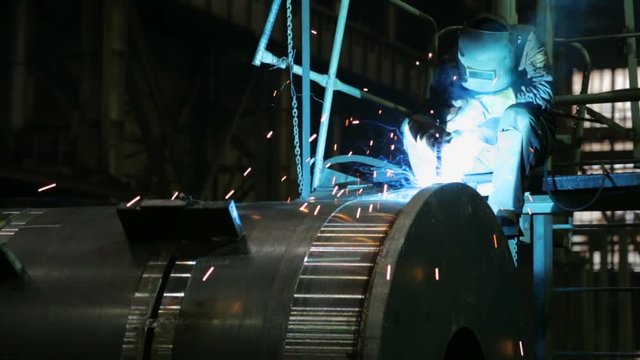 Welder welding metalwork in a factory