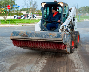 Sweeper attachments mini excavator. The sweeper sweeps, collects and dumps dirt and debris.