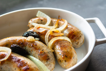 White sausage fried with onions and dried plums.