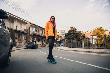 Naklejka premium Girl on a skateboard on the road