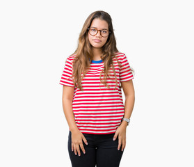 Obraz premium Young beautiful brunette woman wearing glasses and stripes t-shirt over isolated background with serious expression on face. Simple and natural looking at the camera.