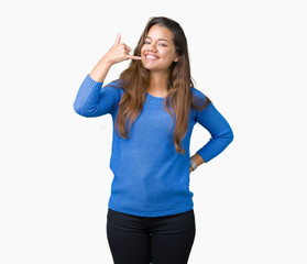 Obraz na płótnie Canvas Young beautiful brunette woman wearing blue sweater over isolated background smiling doing phone gesture with hand and fingers like talking on the telephone. Communicating concepts.