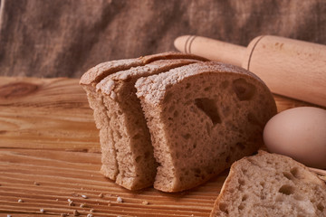 fresh delicious bread, concept for baking. Eggs in clay bowl and wheat sprouts on wooden table