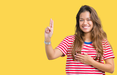 Young beautiful brunette woman wearing stripes t-shirt over isolated background Swearing with hand...